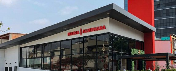 Fachada de Maria Almenara con amplios ventanales, estructura moderna y acceso exterior cubierto.