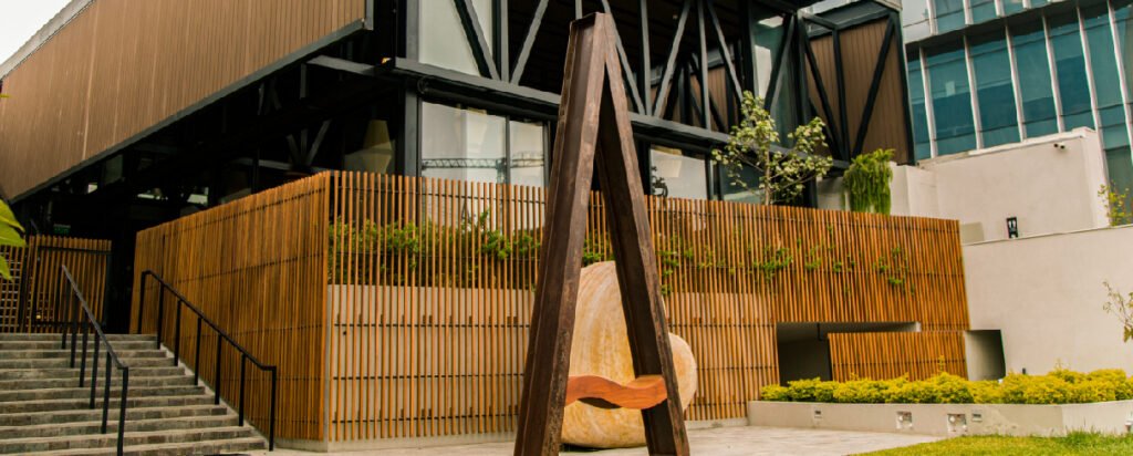 Exterior de AmorAmar con revestimientos de madera, vegetación y una estructura integrada al entorno.