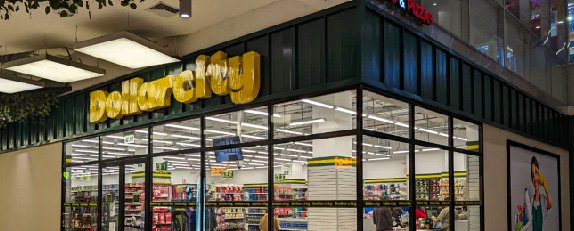 Fachada de Dollarcity con amplios ventanales, señalética visible y vista hacia el interior de la tienda.