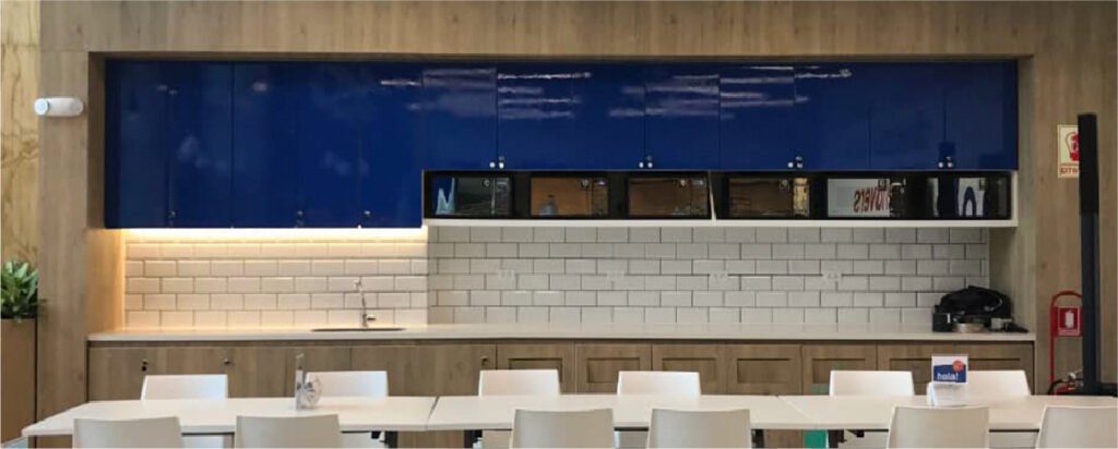Interior de oficinas Entel con mobiliario funcional, acabados en madera, iluminación integrada y espacios de trabajo modernos.